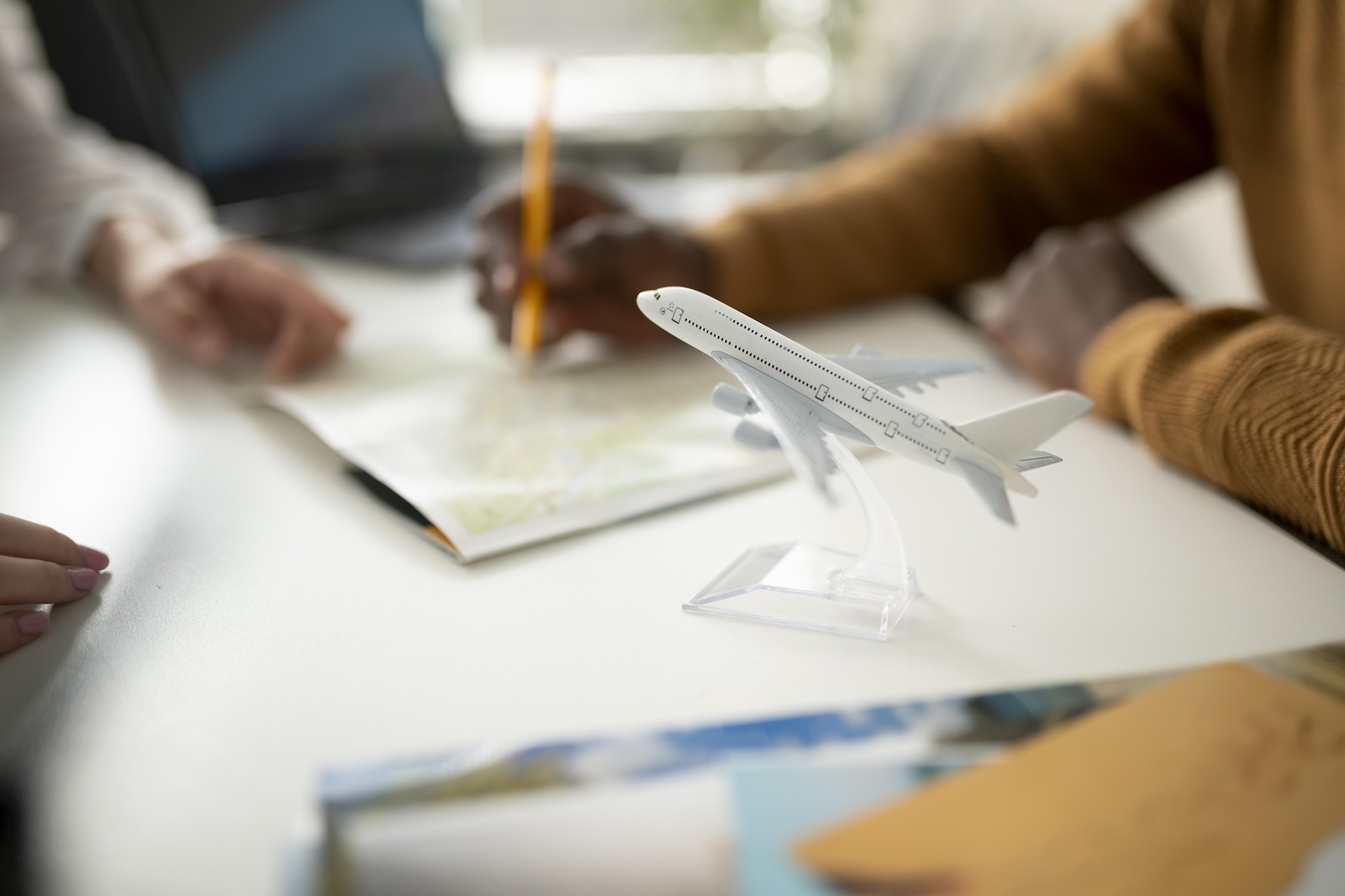 Imagem mostra mesa com papéis e um avião de brinquedo